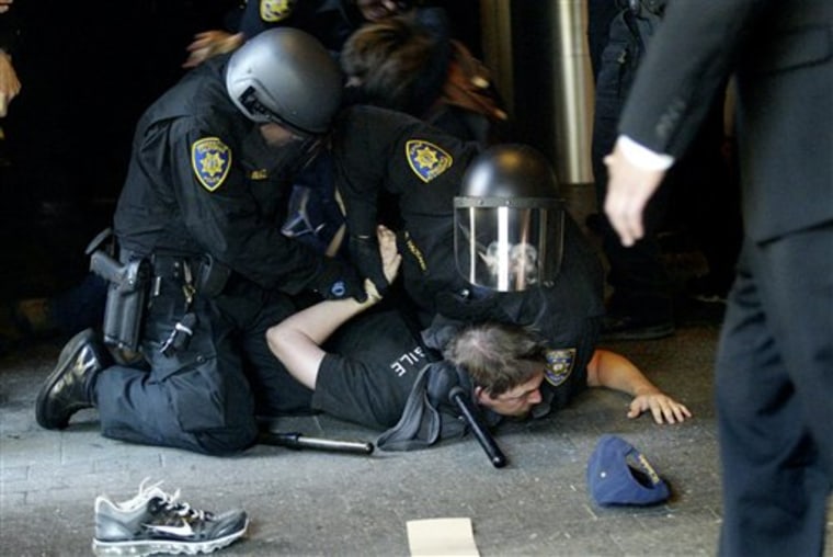 Protesters are handcuffed after breaking a line of University of California police officers at the entrance to the University of California campus in San Francisco, Calif. on Wednesday. Students clashed with police outside a meeting of the UC Board of Regents, which is scheduled to vote on another tuition increase. 